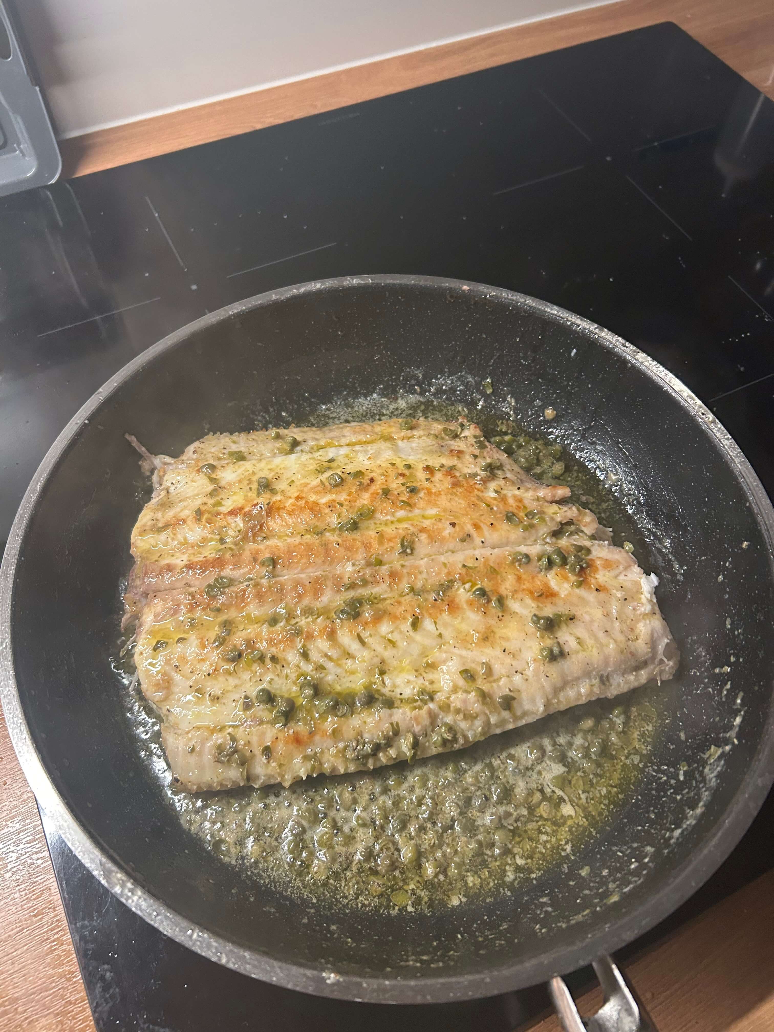 Amateur phone photo of fish with capers before AI enhancement